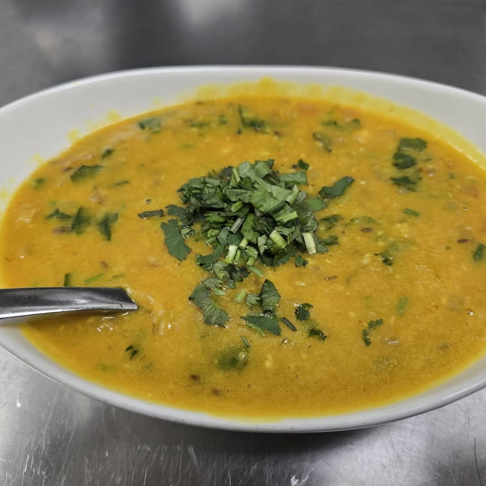 Yellow lentil dish garnished with fresh cilantro.