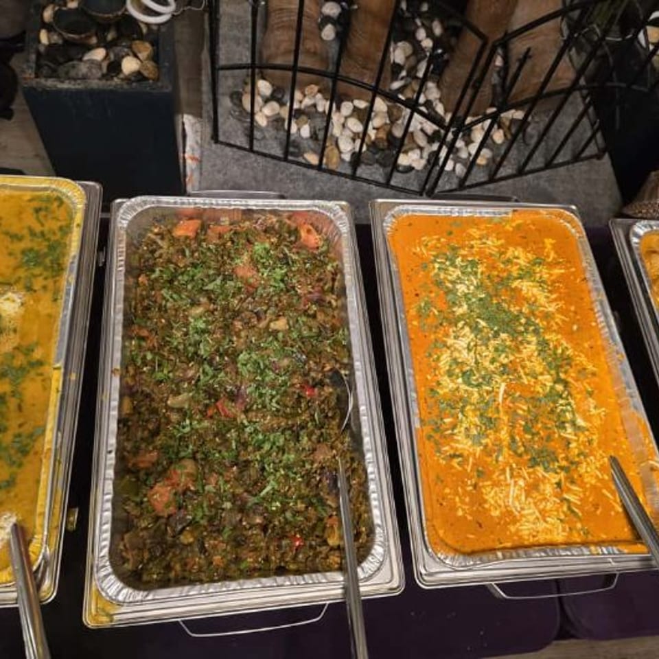 Catering buffet with trays of Indian dishes