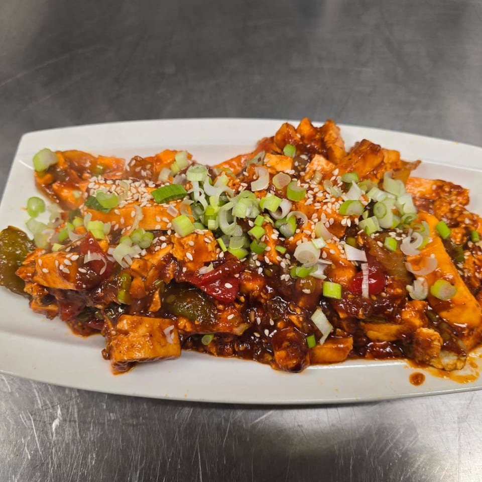 Sauced paneer and vegetables topped with sesame seeds and scallions.